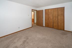 Bloomingdale apartment for rent - an empty living room with a carpeted floor and two closet doors