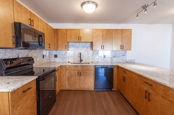 Manistee Township apartment for rent - A kitchen with wooden cabinets and a marble countertop.