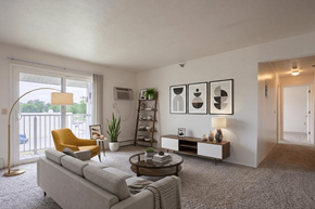 Sturgis apartment for rent - A living room with a grey couch, a yellow chair, a coffee table, and a bookshelf.