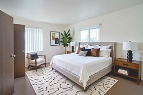 Decatur apartment for rent - A bedroom with a large bed and a wooden nightstand.