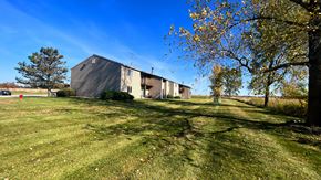 Kingston apartment for rent - a barn with a green lawn and trees in front of it