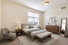 Midland apartment for rent - A bedroom with a bed, nightstand, chair, and mirror.