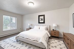 Milan apartment for rent - A bedroom with a large bed, two nightstands, and a framed picture on the wall.