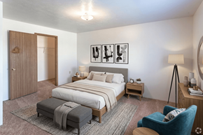 Coldwater apartment for rent - A bedroom with a large bed, a chair, and a rug.