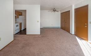Gagetown apartment for rent - an empty living room with a ceiling fan and a kitchen