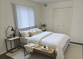 Clio apartment for rent - A bedroom with a large bed and a window with blinds.