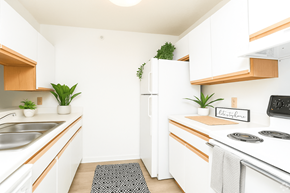 Milan apartment for rent - A kitchen with white cabinets and a white fridge.