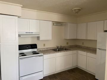 White Pigeon apartment for rent - an empty kitchen with white appliances and white cabinets
