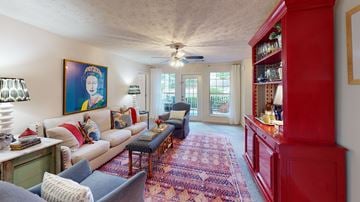 Smyrna apartment for rent - A living room with a red bookcase and a painting of a woman on the wall.