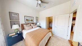 Norcross apartment for rent - A bedroom with a bed, nightstand, and a ceiling fan.