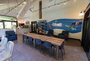 Atlanta apartment for rent - a dining area with a long wooden table with blue chairs and a large mural on the wall