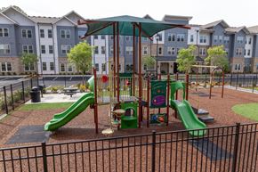 Norcross apartment for rent - A playground with a green slide and a red and yellow play structure.