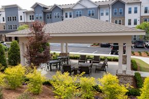 Norcross apartment for rent - A gazebo with a table and chairs is surrounded by yellow flowers.