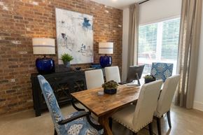 Kennesaw apartment for rent - a dining room with brick walls and a wooden table with white chairs and blue upholstery