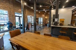 Atlanta apartment for rent - a large wooden table in front of a bar with a man sitting at a table in the