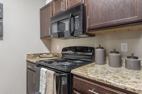 Midland apartment for rent - A black microwave is mounted above a black stove in a kitchen.