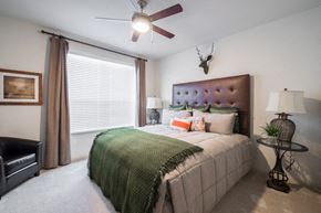 Odessa apartment for rent - A bedroom with a bed, a chair, and a ceiling fan.