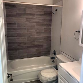 Sayville apartment for rent - a bathroom with a toilet and a bathtub at Brookwood at Sayville, Sayville, NY