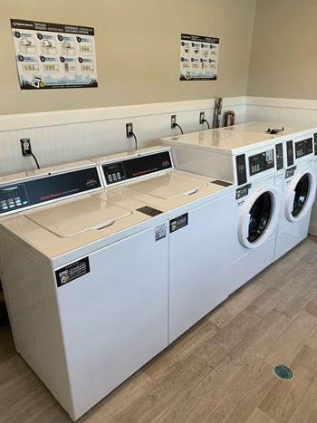 A laundry room with two washers and two dryers  brookwood 