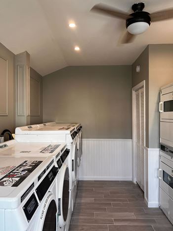 Remodeled kitchen with white appliances and a ceiling fan 