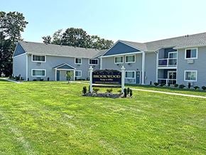 Sayville apartment for rent - a large yard with a sign in front of a building at Brookwood at Sayville, New York