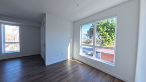 Northridge apartment for rent - A room with a large window showing a view of a building and trees outside.