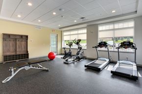 Fairport apartment for rent - A gym with treadmills, a bench, and a ball.