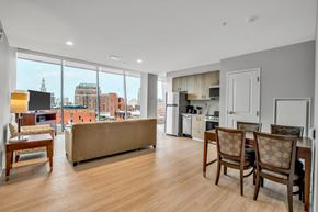 Buffalo apartment for rent - A living room with a couch, chairs, and a view of the city.