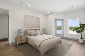 Austin condo for rent - A bedroom with a large bed, a nightstand with a lamp, and a painting on the wall.