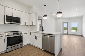 Austin condo for rent - A kitchen with white cabinets and a stainless steel dishwasher.
