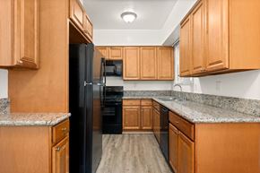 Los Angeles apartment for rent - A kitchen with wooden cabinets and a black refrigerator.