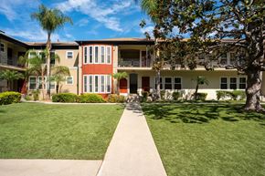 Los Angeles apartment for rent - A building with a red door and a tree in front.