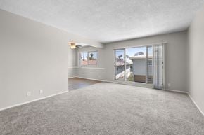 Los Angeles apartment for rent - A spacious room with a carpeted floor and a large window overlooking a street.