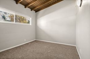Los Angeles apartment for rent - A room with a carpeted floor and a window with a view of trees.