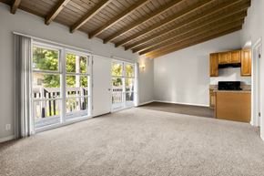 Los Angeles apartment for rent - A spacious room with a wooden ceiling and carpeted floor.