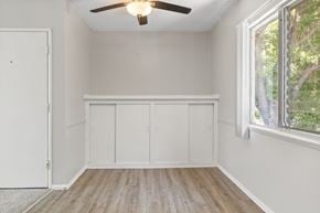 Los Angeles apartment for rent - A room with a ceiling fan and a window with a view of trees.