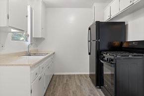 Los Angeles apartment for rent - A kitchen with white cabinets and a black refrigerator.