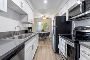 Woodland Hills apartment for rent - a kitchen with white cabinets and black appliances at Lombardi Apartments, Woodland Hills, CA, 91367
