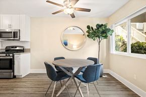 Los Angeles apartment for rent - Dining Room with Round Dinner Table, Blue Chairs, Tall Potted Plant, and Ceiling Fan at Casa De Marina Apartments, Los Angeles, California
