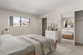 Sherman Oaks apartment for rent - A bedroom with a large bed and a dresser with a mirror.