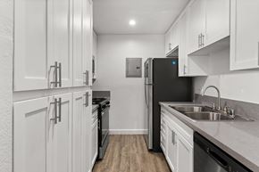 Sherman Oaks apartment for rent - A kitchen with white cabinets and a black refrigerator.