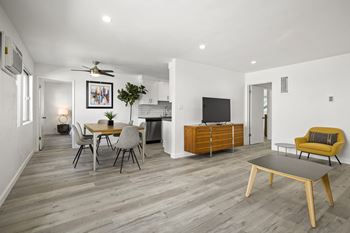 A modern living room with a dining table and chairs.