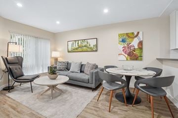 North Hollywood apartment for rent - A living room with a grey couch, a white coffee table, and a painting on the wall.