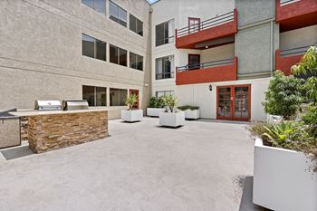 A courtyard with a stone wall and potted plants.