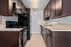 Newbury Park apartment for rent - a kitchen with dark cabinets and a black stove top oven