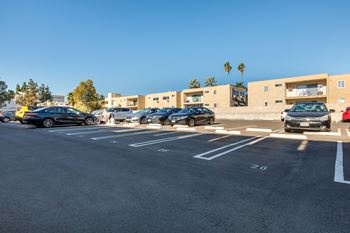 A parking lot with cars parked in front of a building