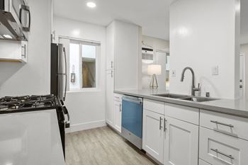 A kitchen with white cabinets and a black stove top.
