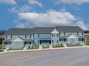 Middletown townhouse for rent - A large house with a grey roof and a stone wall.