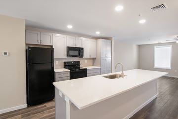 Middletown townhouse for rent - A kitchen with black appliances and white countertops.