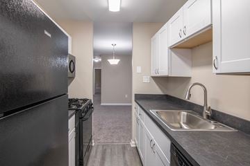 Harrisburg apartment for rent - A black refrigerator is in a kitchen with white cabinets.